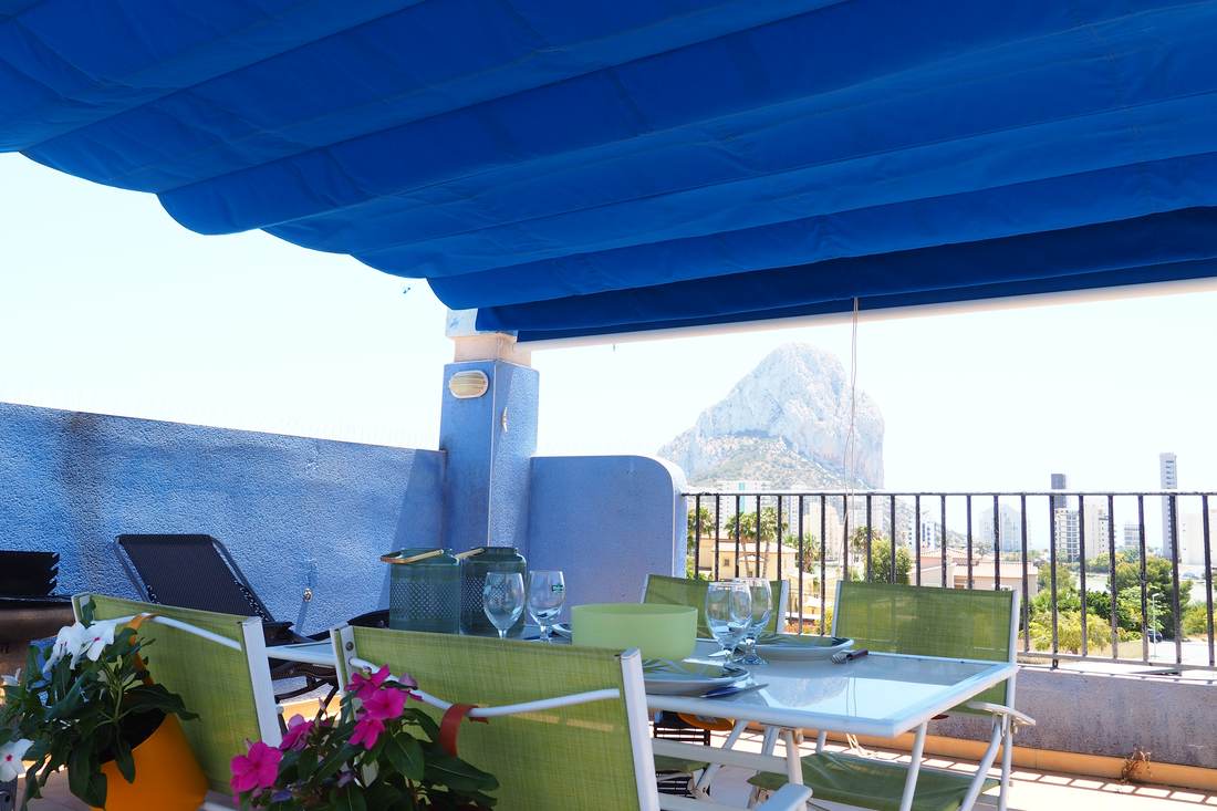 El toldo azul de la terraza recortado sobre el mar y el Peñón