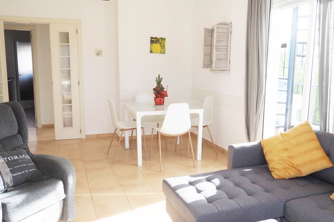 Comedor blanco con la mesa, las sillas y la entrada de luz