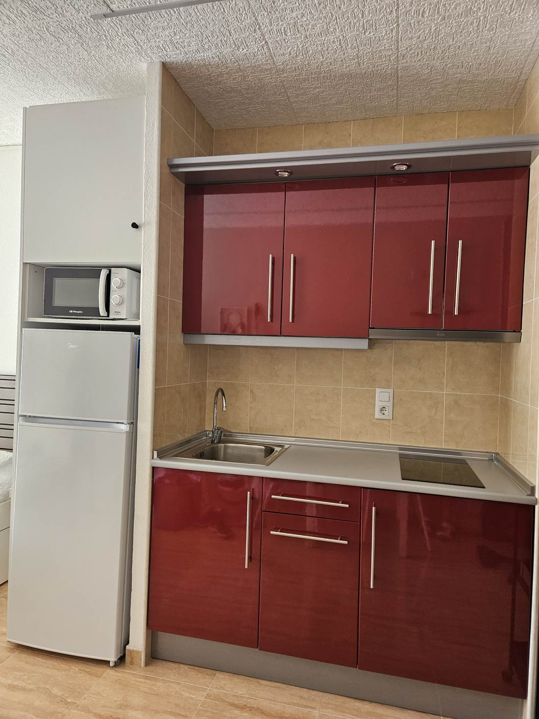 Cocina reformada con los frentes en rojo y la nevera grande