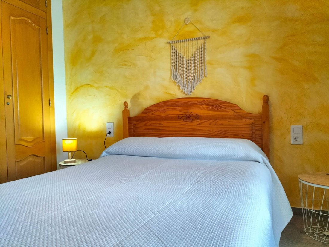 Dormitorio de matrimonio con cabecero de madera