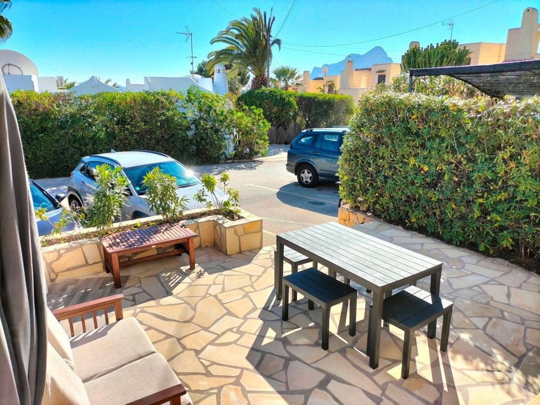 Terraza con mesa de exterior y el aparcamiento justo delante