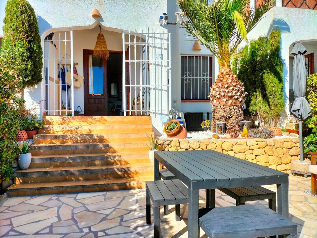 Entrada al bungalow por la escalera, con plantas a los lados