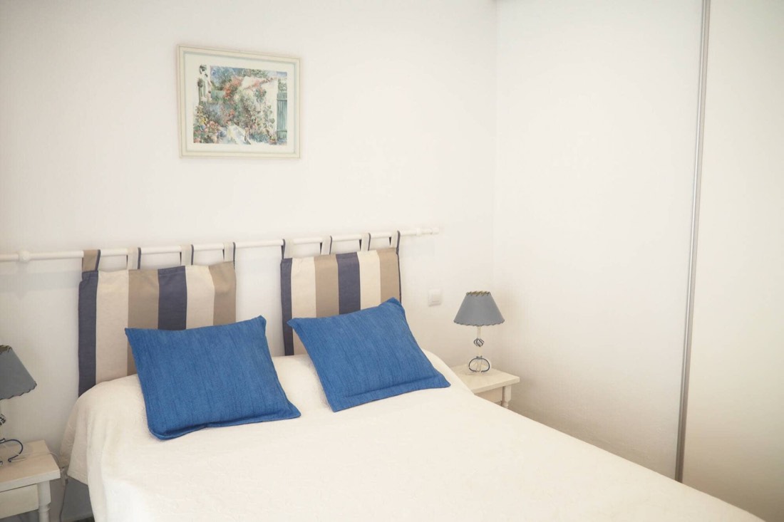 Dormitorio principal con cama doble y cojines azules