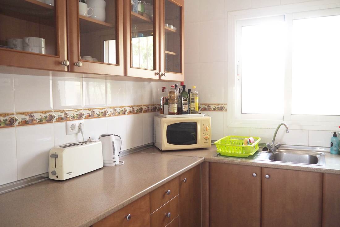 Cocina independiente con muebles de madera, horno y lavavajillas
