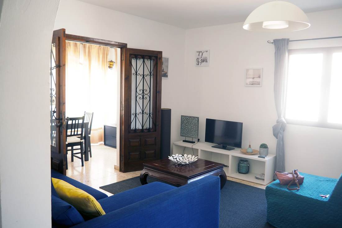 El salón visto desde el comedor, con las puertas de madera abiertas