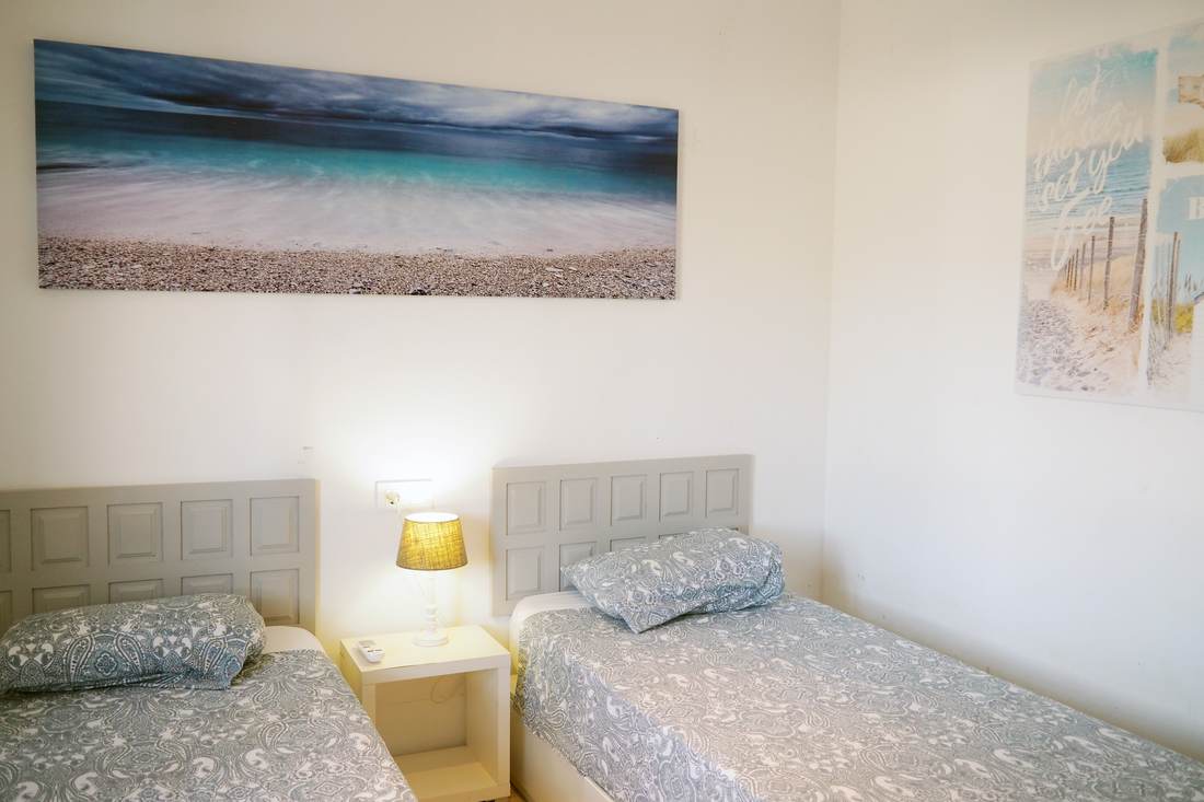 Dormitorio con dos camas individuales y ventana al jardín