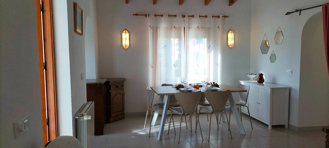 Comedor de Casa Margarita con la mesa puesta junto al ventanal