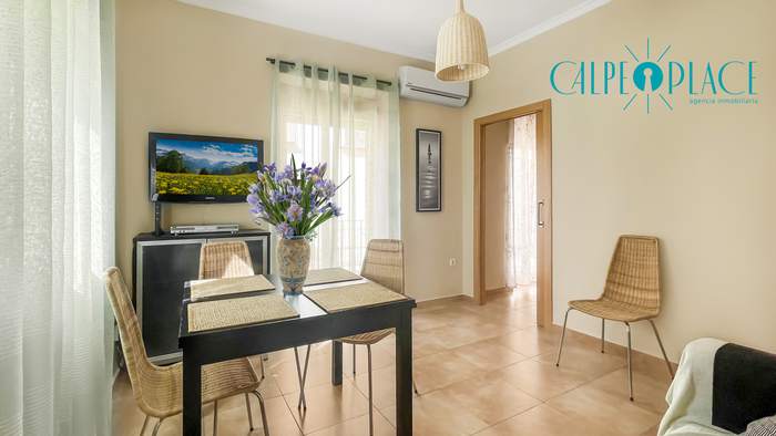 Salón comedor de Denia Centro con el televisor y la cocina al fondo