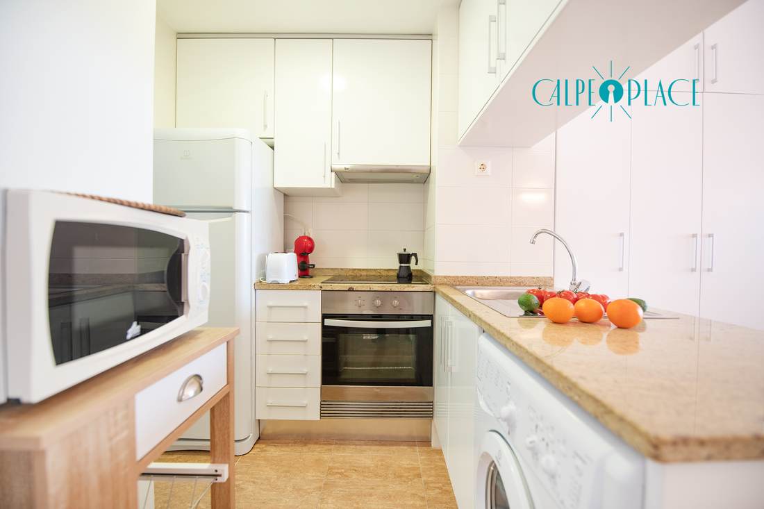 Cocina independiente con microondas, horno, lavadora y encimera de granito