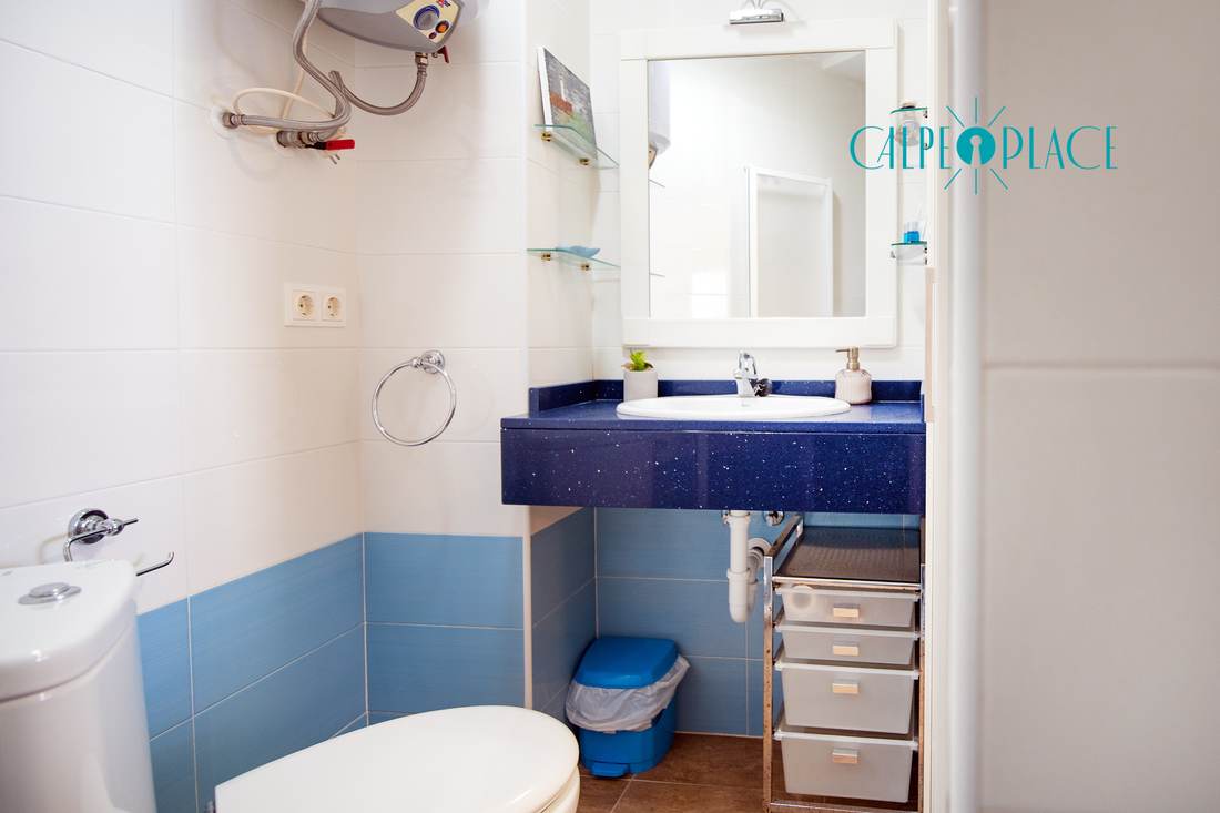 Baño completo alicatado en azul, con lavabo, inodoro y bidé