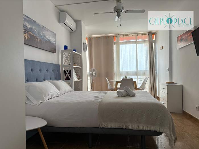 Estudio Dorada con la cama, el ventilador de techo y la luz del mar entrando por la ventana