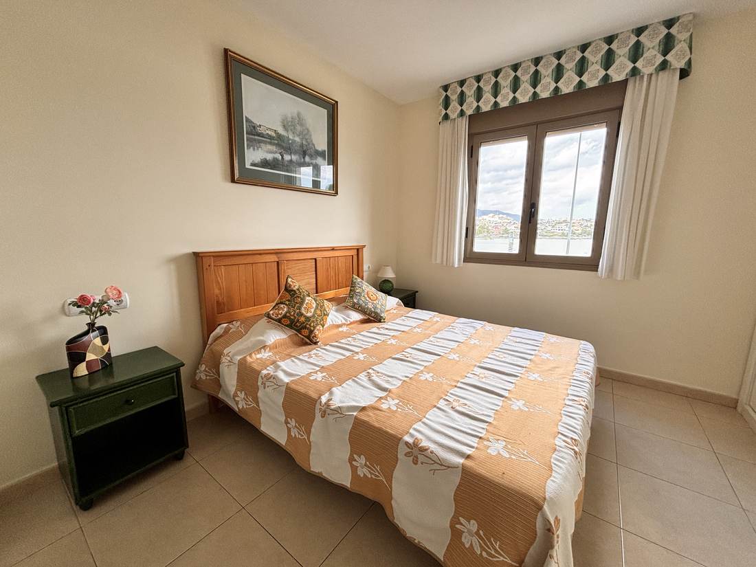 Dormitorio principal con cama de matrimonio y cabecero de madera