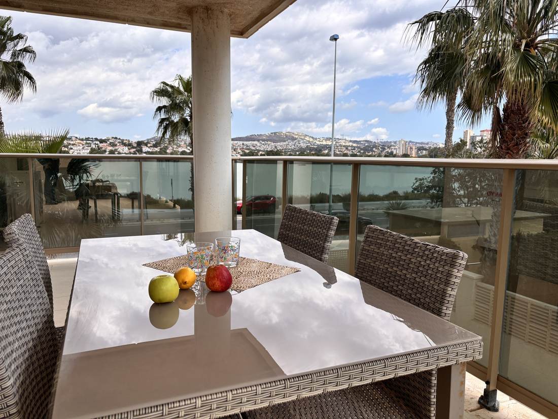 Mesa puesta en la terraza, con la fruta y las vistas