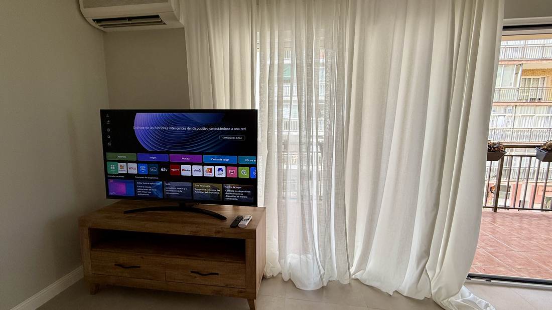 El salón con el televisor y el ventanal a la terraza