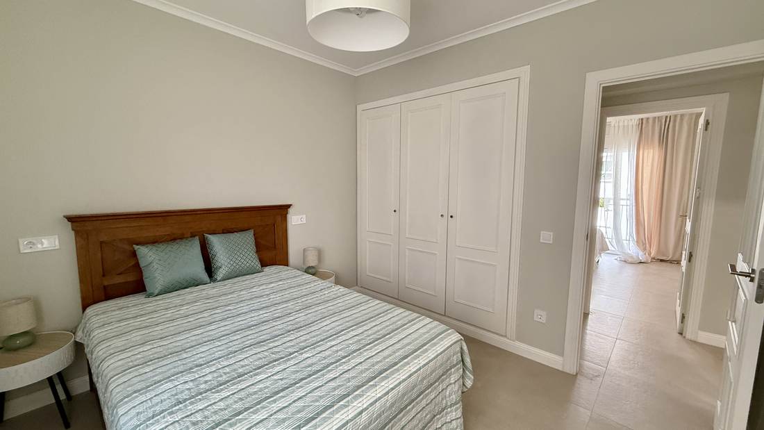 Dormitorio con cama de matrimonio y cabecero de madera