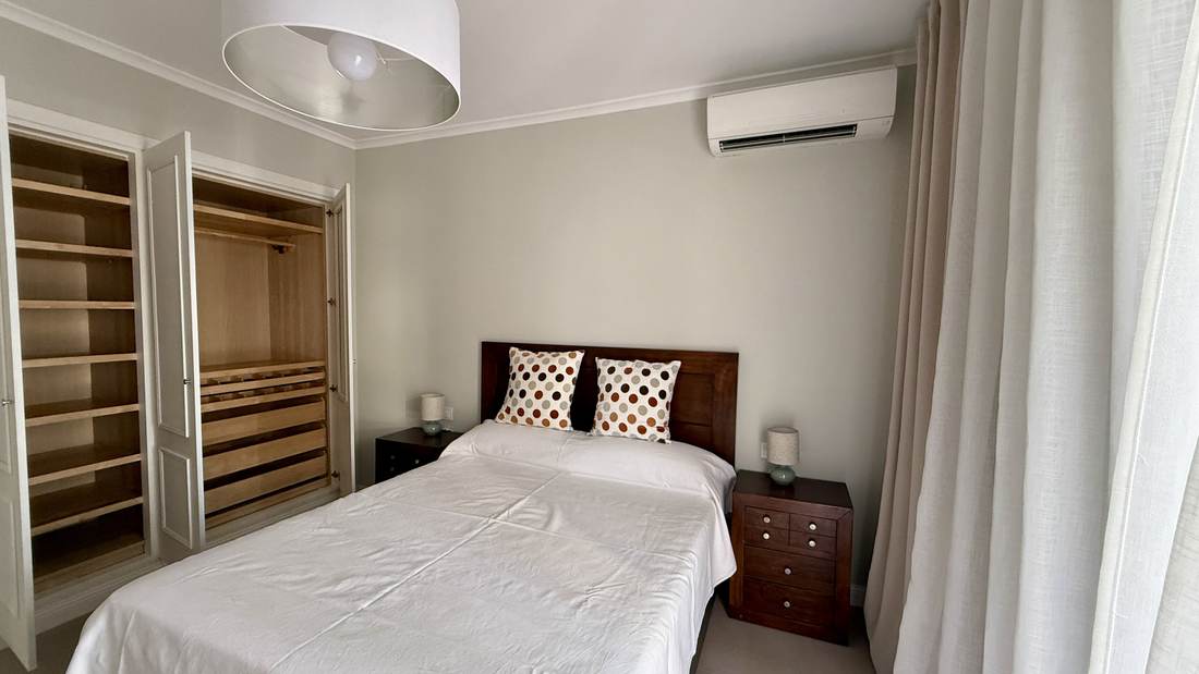 Dormitorio con dos camas individuales y armario abierto