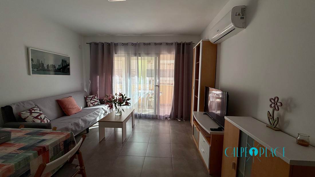 Salón con sofá gris y la puerta corredera de la terraza