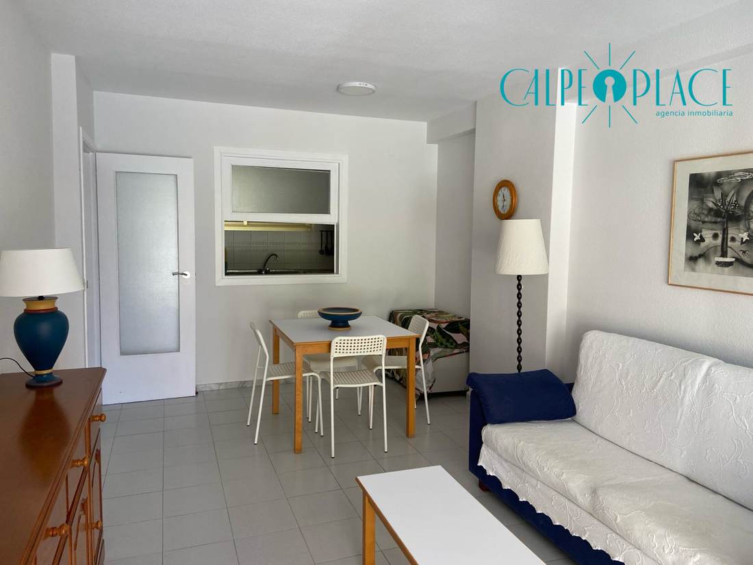 Salón y comedor, con el sofá y la mesa junto a la entrada