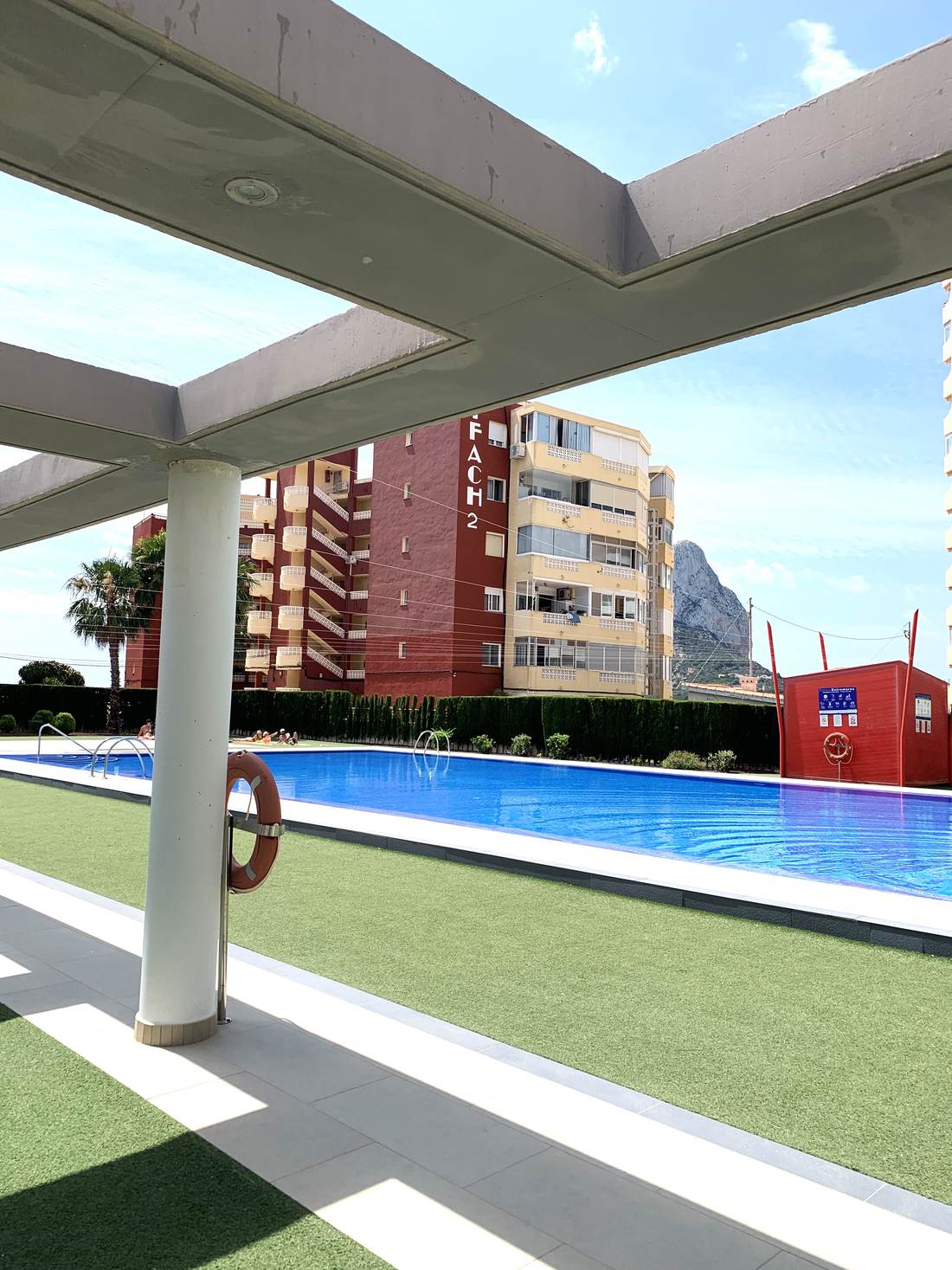 La piscina del edificio bajo la pérgola blanca