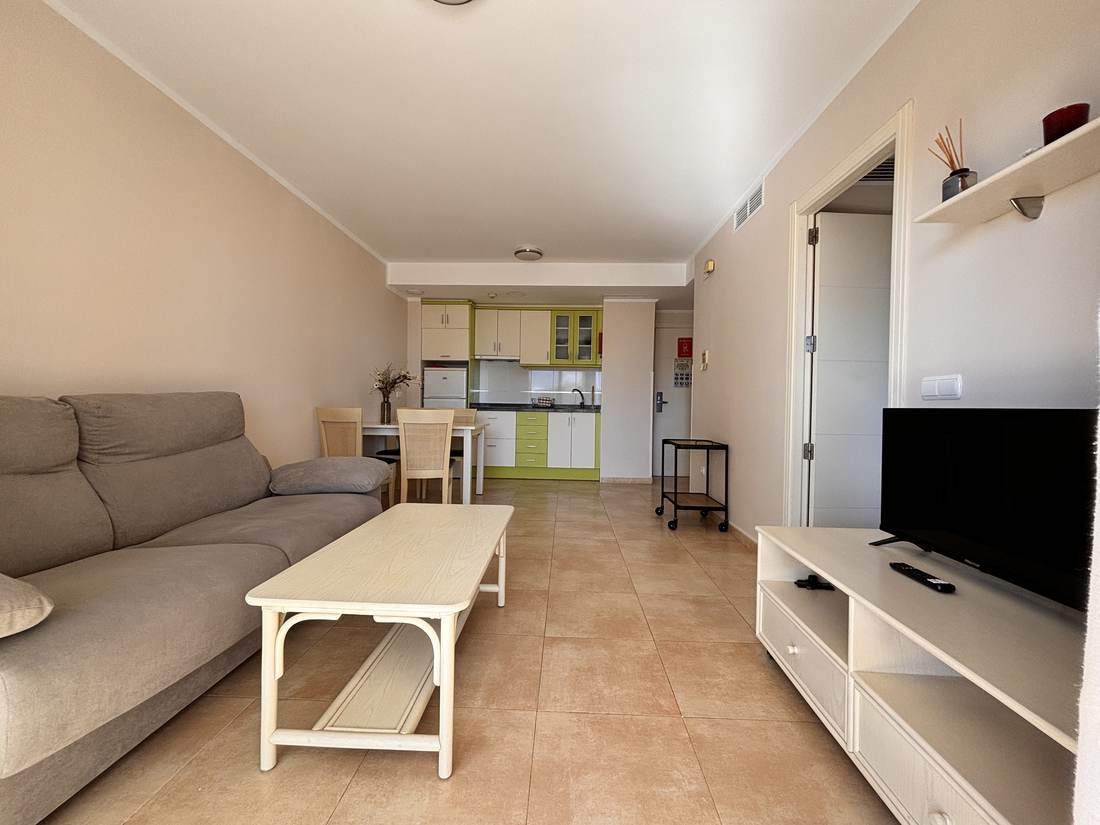 El salón desde la entrada, con la televisión y la cocina al fondo