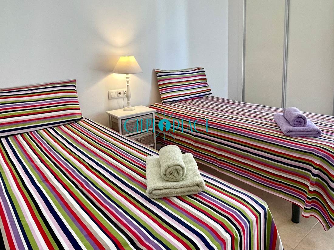 Segundo dormitorio con dos camas individuales y cabeceros de rayas