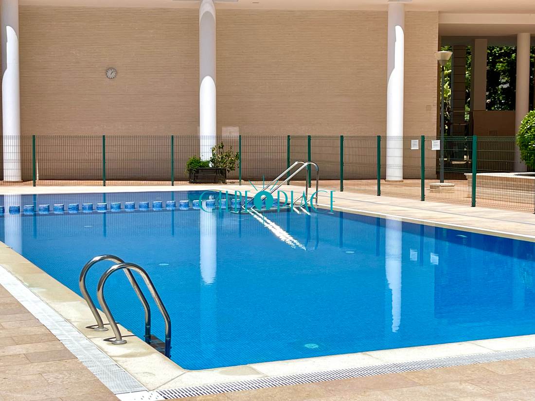 Piscina comunitaria del edificio, con el solárium alrededor