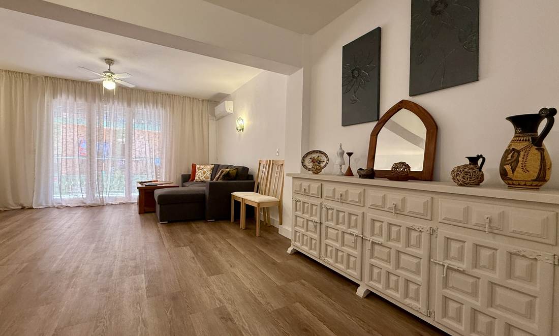 Salón comedor muy amplio, con suelo de madera y el aparador blanco