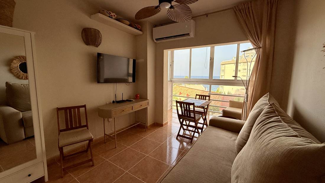 Salón reformado con el ventanal abierto al mar