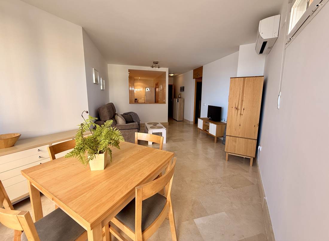 Mesa de comedor de madera con el salón detrás