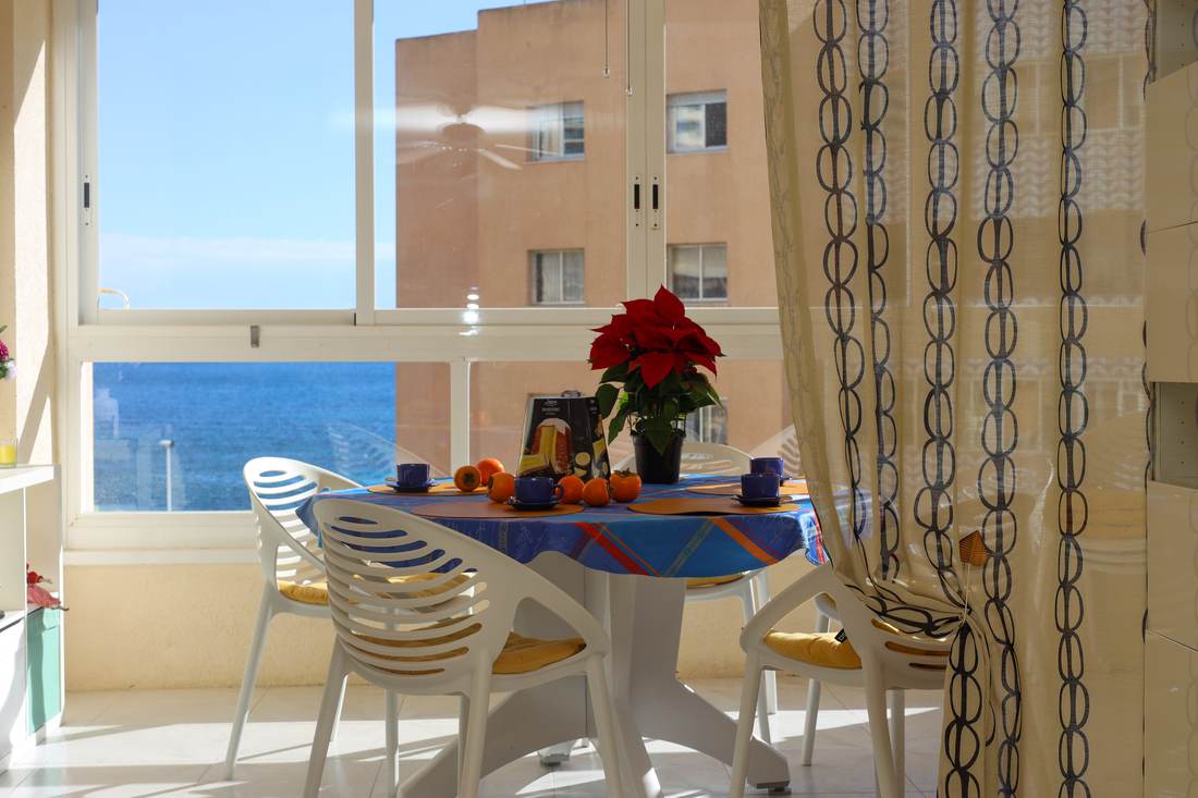 Galería con mesa y sillas y vistas a la bahía