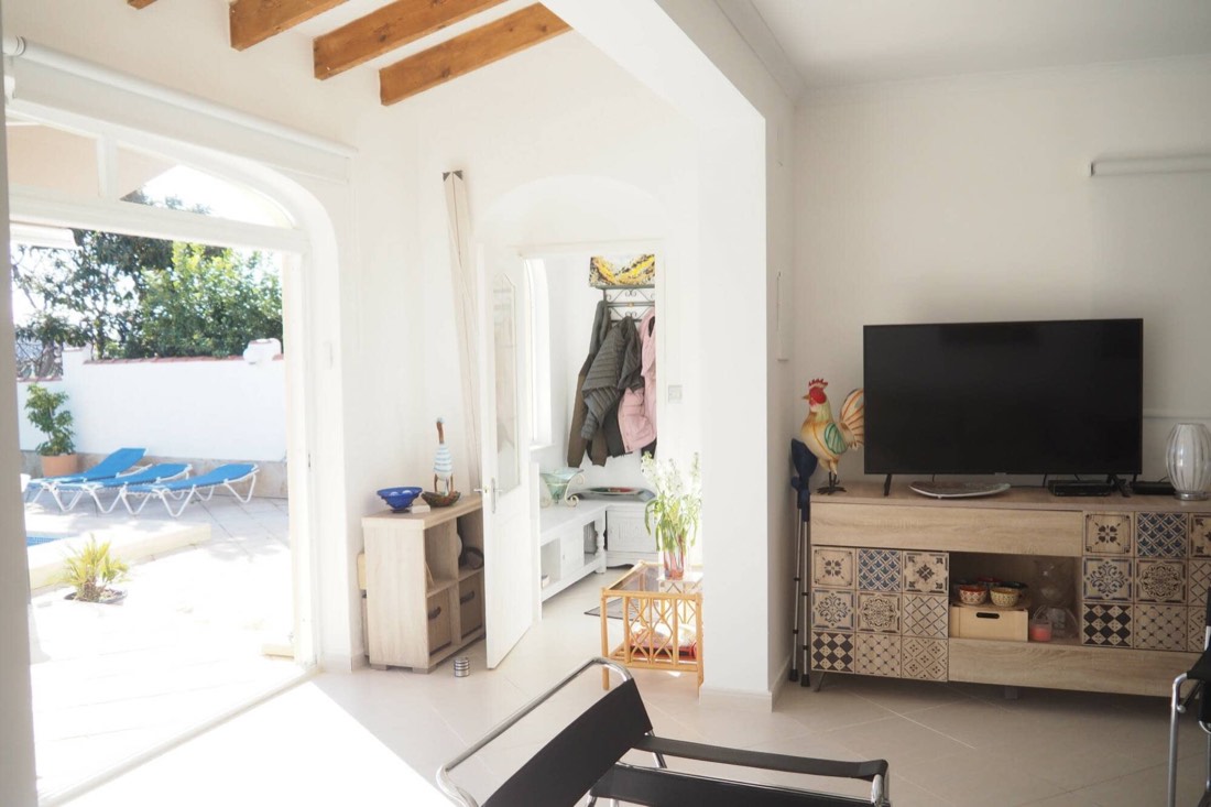 Salón con televisión y puerta corredera al jardín