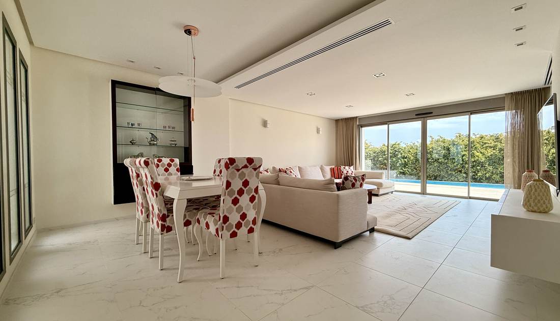 Salón-comedor abierto, con el ventanal corrido a la piscina